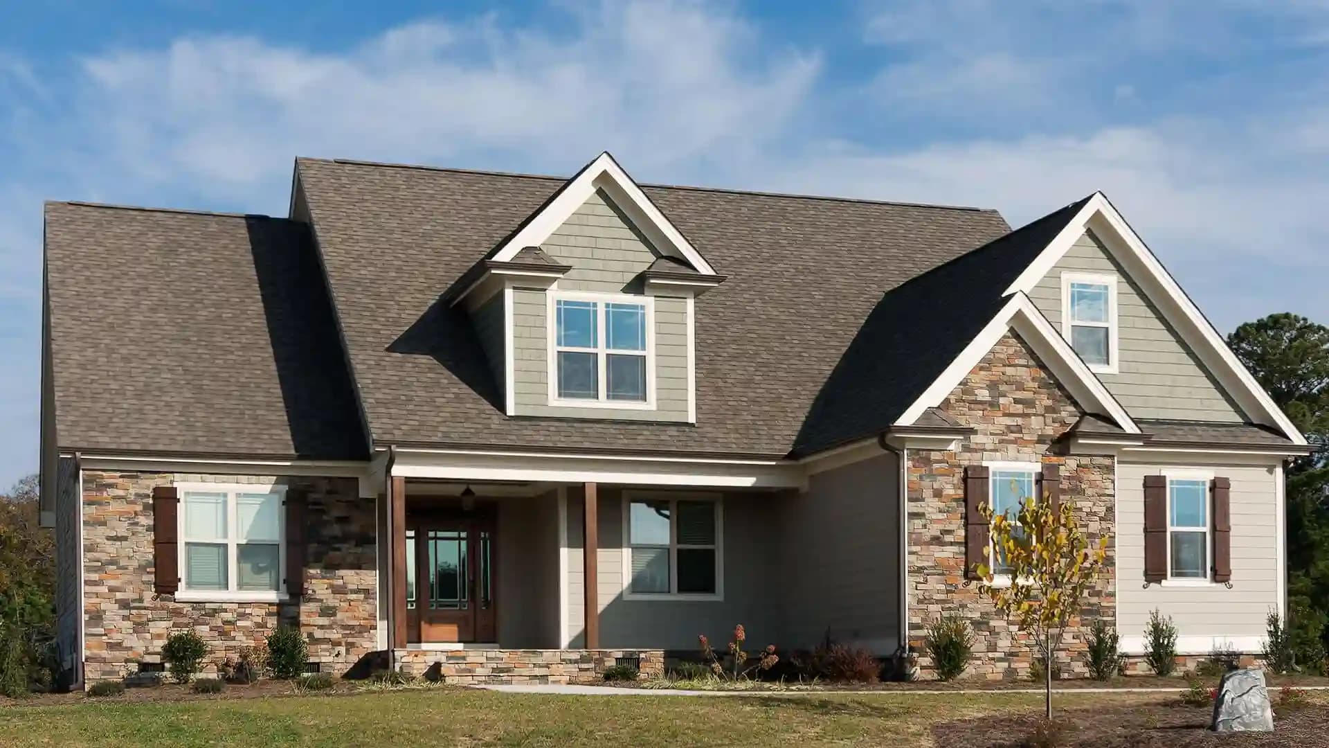 Craftsman-style home with a freshly installed architectural shingle roof under a blue sky